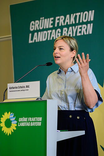 Katharina Schulze steht an einem Rednerpult und spricht in ein Mikrofon