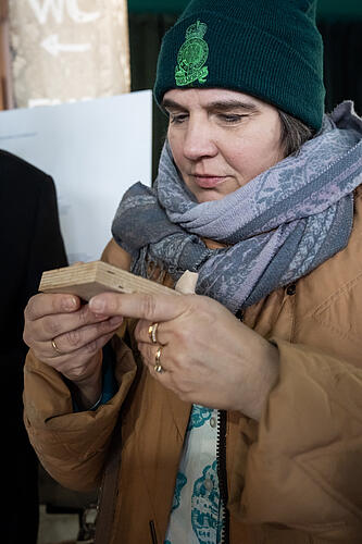 Claudia Köhler, MdL, betrachtet das Muster eines Holzwerkstoffs. 