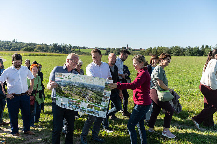 Christian Graf, Bürgermeister von Freinberg, Stefan Kaineder, Umwelt- und Klimalandesrat, Land Oberösterreich, und Katharina Schulze, MdL, blicken gemeinsam auf die Landkarte bei der Wanderung "Hier atmet Europa", Grüne Bayern und Österreich, Fraktionsklausur 2025, Passau.