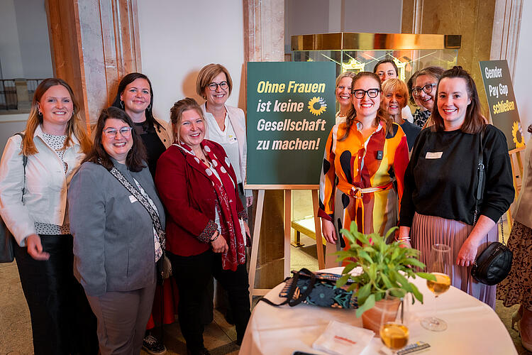 Eine Gruppe Frauen steht um ein Schild mit der Aufschrift "Ohne Frauen ist keine Gesellschaft zu machen!"