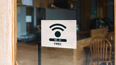 Schild hinter Scheibe mit der Aufschrift "Wi-Fi free"