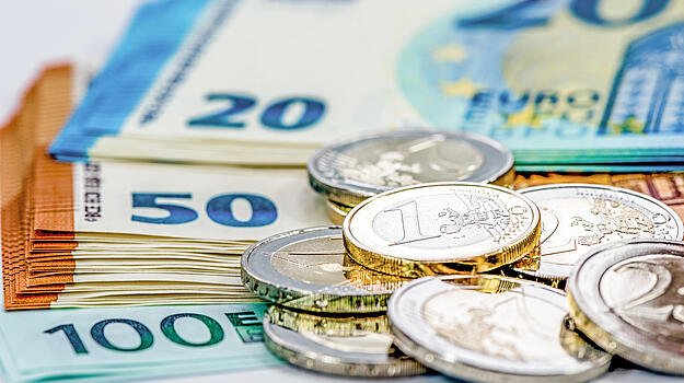 20,50 und 100 Euro Scheine aufgefächert, im Vordergrund einige Münzen