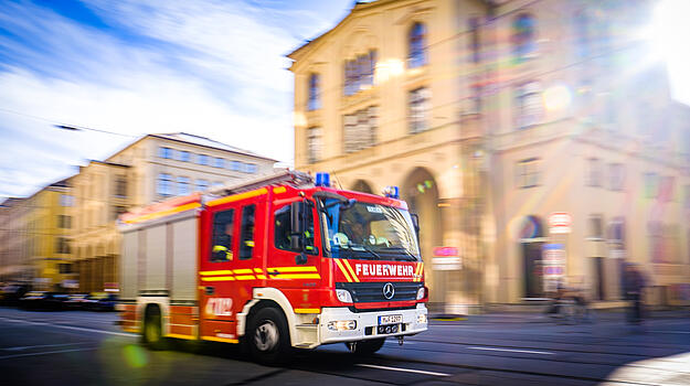 Fahrendes Feuerwehrauto im Hintergrund Gebäude