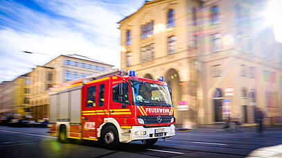 Fahrendes Feuerwehrauto im Hintergrund Gebäude