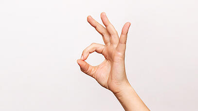 Eine Hand legt Zeigefinger und Daumen aufeinander und spreizt die restlichen Finger ab.