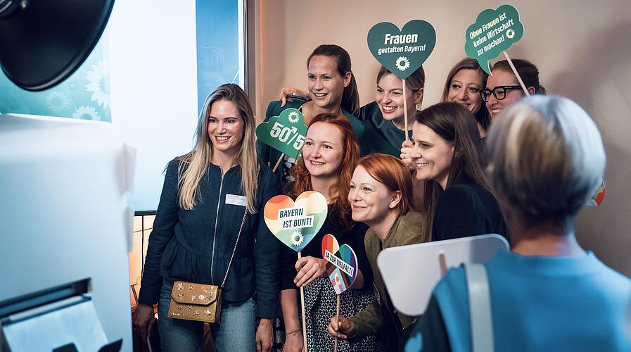 Eine Gruppe Frauen posiert für ein Foto und hält dabei kleine Schilder mit feministischen Sprüchen nach oben