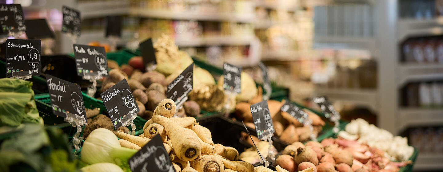 Ausgestelltes Gemüse mit Preis- und Namensschild in einem Supermarkt