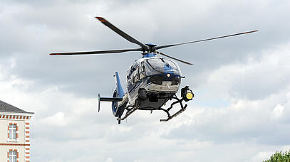Ein Polizeihubschrauber schwebt vor bewölktem Himmel
