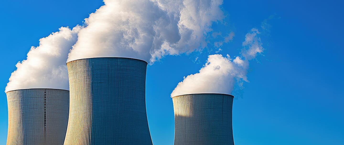 Aus drei großen Kühltürmen steigt weißer Dampf aus.