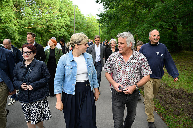 Katharina Schulze und Dr. Dag Encke gehen durch den Nürnberger Tiergarten, neben ihnen und im Hintergrund weitere Abgeordnete