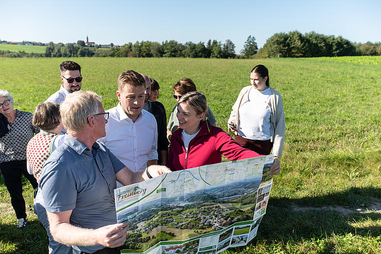 Christian Graf, Bürgermeister von Freinberg, Stefan Kaineder, Umwelt- und Klimalandesrat, Land Oberösterreich, und Katharina Schulze, MdL, blicken gemeinsam auf die Landkarte bei der Wanderung "Hier atmet Europa", Grüne Bayern und Österreich, Fraktionsklausur 2025, Passau.