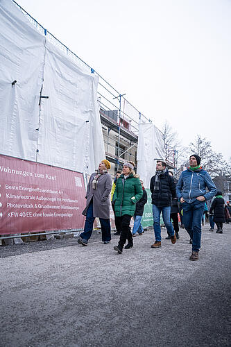 Eine Gruppe Abgeordnete auf dem Weg zum Ortstermin in Riem.