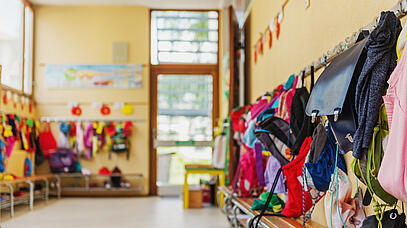 Garderobe mit vielen Kinderrucksäcken und Kinderjacken.