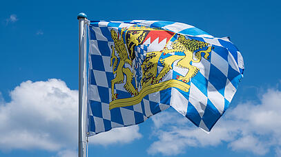 Blau-weiß karierte Fahne vor blauem Himmel