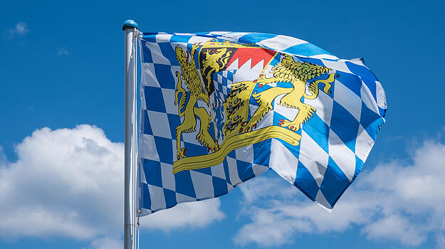 Blau-weiß karierte Fahne vor blauem Himmel