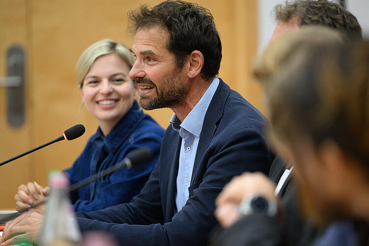 Martin Stümpfig, MdL, spricht in ein Tagungsmikrofon, im Hintergrund Katharina Schulze