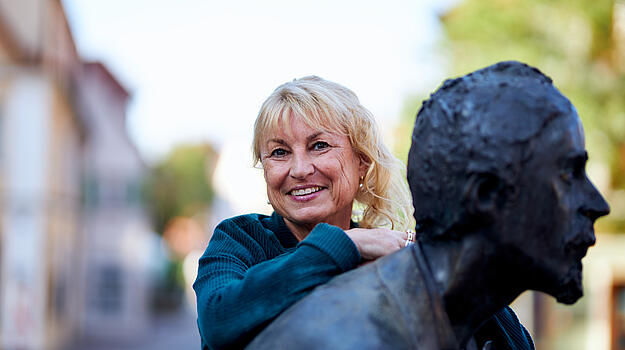 Dr. Sabine Weigand, MdL auf eine Statue gelehnt