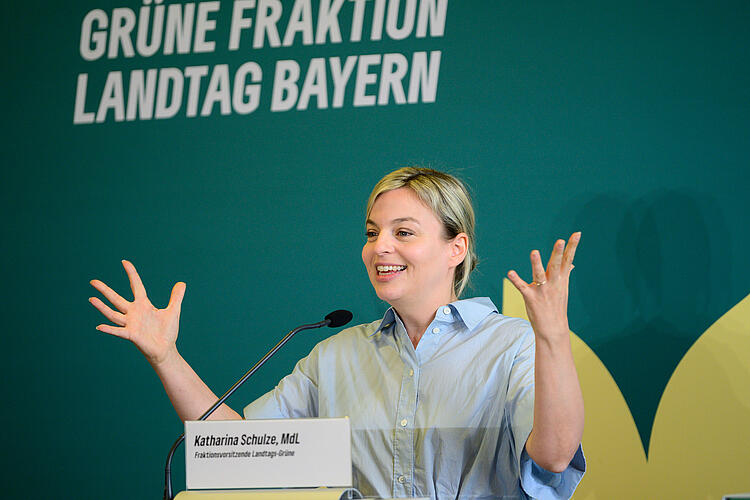 Katharina Schulze spricht an einem Rednerpult. Beide Hände zu einer Geste erhoben.